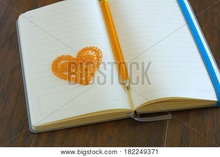 Heart symbol with pencil on open blank notebook page. Love message romance concept. Lyrics loveletter book.