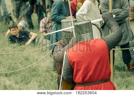 RITTER WEG MOROZOVO APRIL 2017: Festival of the European Middle Ages. Medieval joust knights in helmets and chain mail battle on swords with shields in their hands.