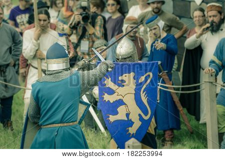 RITTER WEG MOROZOVO APRIL 2017: Festival of the European Middle Ages. Medieval joust knights in helmets and chain mail battle on swords with shields in their hands.