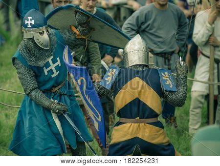 RITTER WEG MOROZOVO APRIL 2017: Festival of the European Middle Ages. Medieval joust knights in helmets and chain mail battle on swords with shields in their hands.