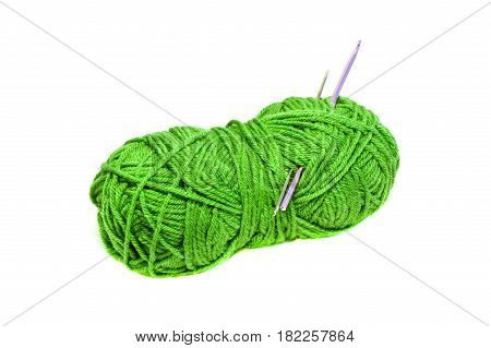 Green yarn clew with crochet hooks isolated on white background