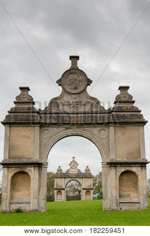 Stone Monument With Two Arches In A Formal English Garden