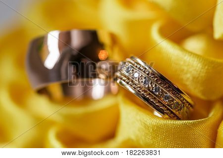 diamond ring on yellow flower. wedding rings together. selective focus.