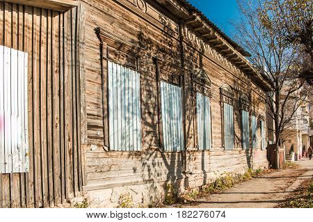 Old House With Windows Closed By Melall, Bright Sunny Day With Blue Sky.