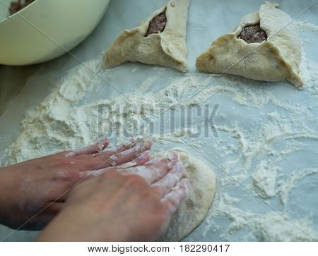 Mixing of dough. Baking peremech concept. Flour, dough and meat cooking ingredients. Hands top view of cooking belyash cuisines. ground meat with hole
