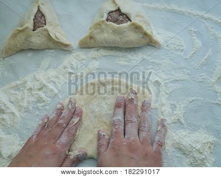 Mixing of dough with flour. Baking peremech concept. Flour, dough and meat cooking ingredients. Hands top view of cooking belyash cuisines. ground meat with hole