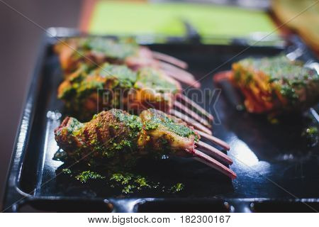 Different stages of cooking the steak on a kitchen, barbeque, roasted lamb ribs, big dish plate with roasted full pork head, served in restaurant with vegetables, lamb, ham and chicken.