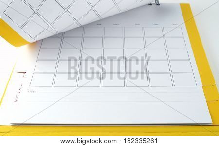 close-up open blank yellow desk calendar with grid and empty lines for write short notes on white background, flip the calendar page