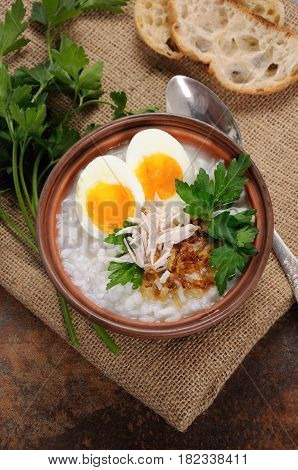 Rice porridge ginger congee with egg chicken crispy shallots and parsley