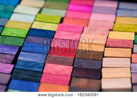 Spectrum of multi colored wooden blocks aligned. Background or cover for something creative or diverse.?Intentionally shot with extremely shallow depth of field.