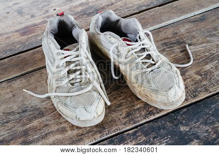 Old sport shoes on the wooden floor