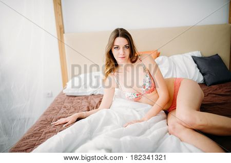 Beautiful Naked Pretty Sensual Brunette Girl Sitting On The Bed And Looking Out The Window At The Mo