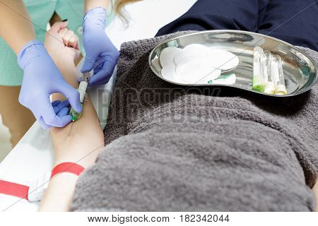 nurse taking blood sample from patient's arm. Preparation of blood to the procedure Plasmolifting.
