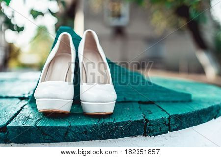 bride's biege shoes on heel on a wooden board tiffany colour.