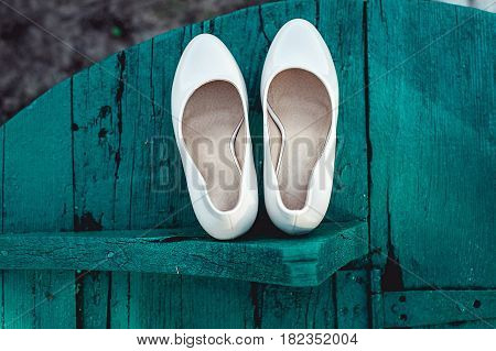 bride's biege shoes on heel on a wooden board tiffany colour.