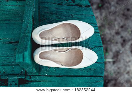 bride's biege shoes on heel on a wooden board tiffany colour.