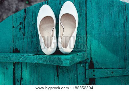 bride's biege shoes on heel on a wooden board tiffany colour.