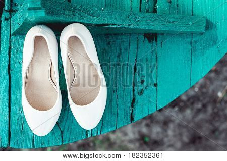 bride's biege shoes on heel on a wooden board tiffany colour.