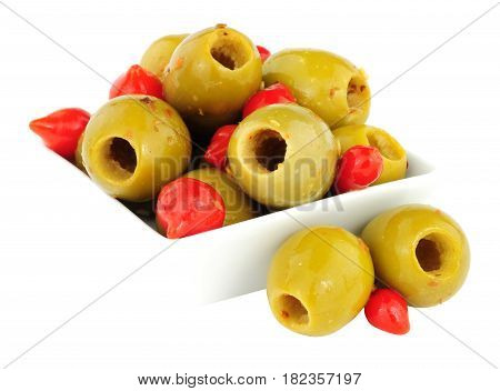 Dish of green gordal olives and sweet red piquante chilli peppers isolated on a white background
