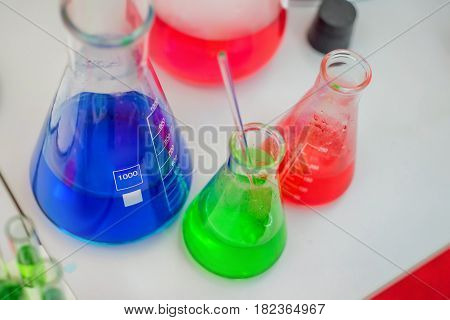 Laboratory expreriment with test-tubes with colored chemical reagents, retorts and flasks
