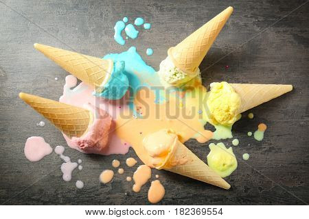 Melted ice-cream cones on gray background