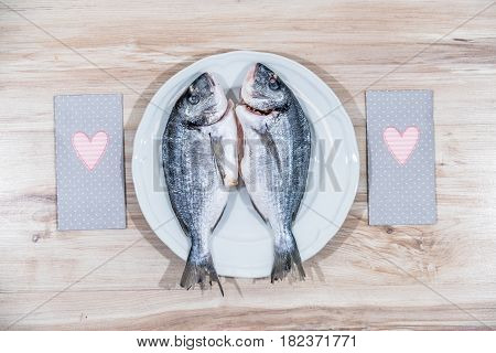 Two grilled seabreams on a plate ready for the barbecue