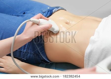 Young woman undergoing ultrasound scan in modern clinic