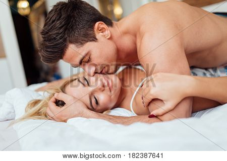 Happy couple in bedroom enjoying sensual foreplay