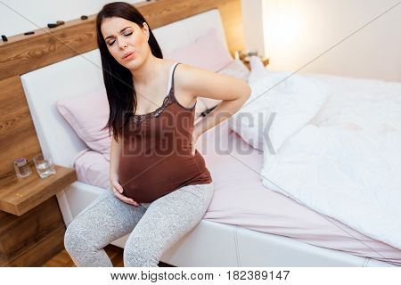 Pregnant woman having back aches in the last trimester of pregnancy