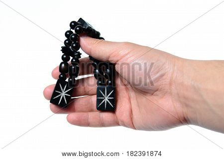Rosary in hand on a white background isolated.