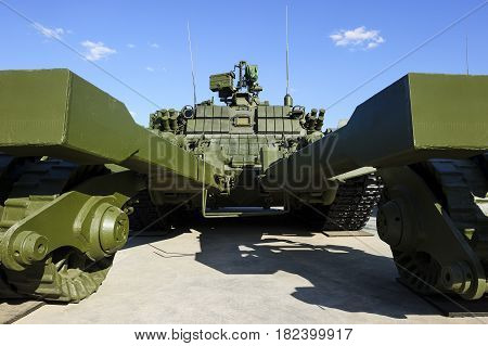 Demining military vehicle, armored mine clearing tank of green color, mine detector transportation, modern heavy army industry, blue sky on background