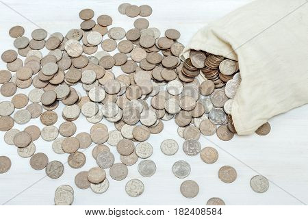 Money bag and silver coins on white background. Flat lay style