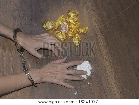 The chrome metal handcuffed bondage on man hand during holding gold bar represent the crime fraud and punishment equipment concept related idea. Addictive substance no freedom Translation in English meaning lucky and richly