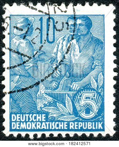 GERMANY - CIRCA 1955: A stamp printed in Germany (GDR) is dedicated to the five-year plan shows worker peasant and intellectual circa 1955