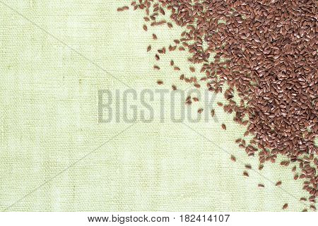 background of dry flax seeds on linen napkin.