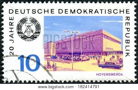 GERMANY - CIRCA 1969: A stamp printed in Germany (GDR) dedicated to the 20th anniversary of the GDR shows the Arms of Republic and View of Hoyerswerda circa 1969
