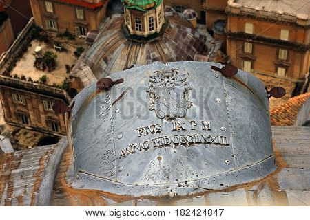 tin canopy on roof of dome of St. Peter's Cathedral in Rome with inscription