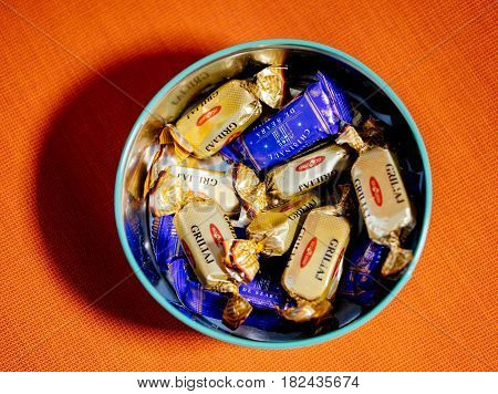 PARIS FRANCE - APR 9 2017: Mix of Griliaj and Chisinaul de Seara from BUCURIA candy factory fromRepublic of Moldova against red textile background