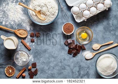 Brownie dough preparation cookie or chocolate cake recipe ingridients, sweet food flat lay top view on concrete kitchen table background. Work with butter, flour, sugar bakery cooking. Text space
