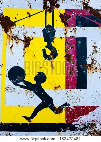 KYIV UKRAINE - JUNE 17 2014: Old rusty construction safety poster. Child playing with a ball in the construction site under the crane's hook.