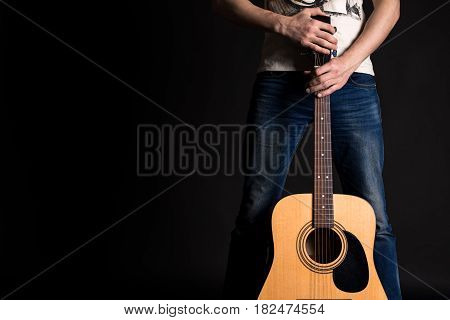 Guitarist holding two hands with an acoustic guitar