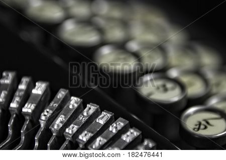 Vintage Keyboarding: Classic 1940's typewriter with bokeh keyboard and black background. Suitable for placement in business offices and hotel rooms that cater to a business clientele.