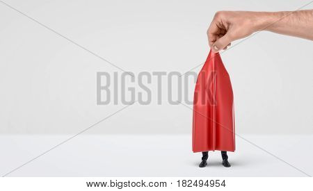 A giant hand taking off a red drapery from a hidden businessman on white background. Unveiling mystery. Legal check-up. Safe business.