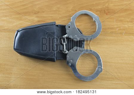 Leather handcuffs on the wooden floor with selective and soft focus.