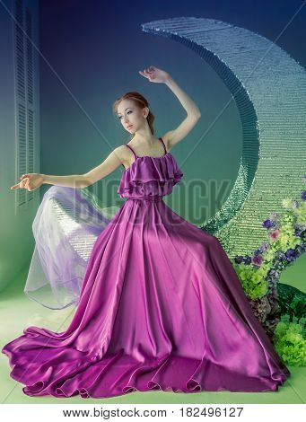 Cute girl dancer in a beautiful dress posing in the studio. Tinted photos.