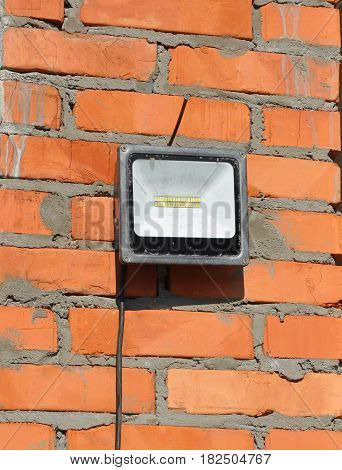 LED flood light spot light on the top house construction site outdoor. Waterproof LED Floodlights Or Lawn Lighting on the Construction Site.