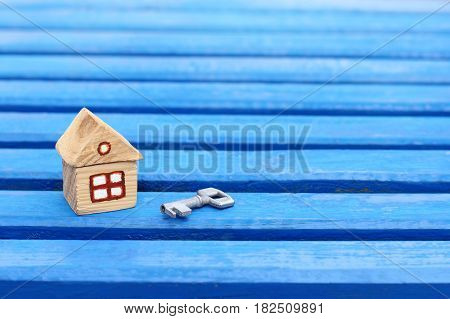 small wooden house with a key on a blue wooden surface / turnkey solution for individual accommodation
