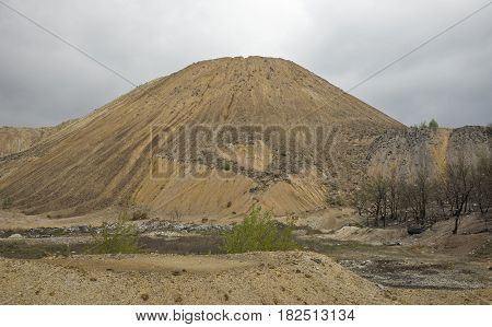 Red artificial lake and hills as a result of mining and production of copper