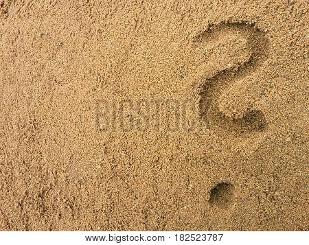 question mark drawn in the sand at the beach