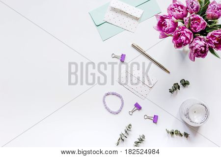 Work desk with spring flowers in home office concept on white background top view space for text